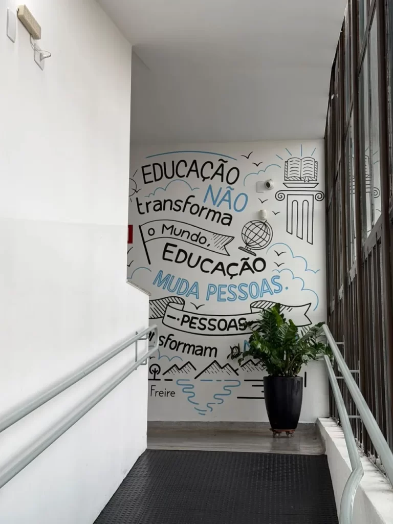 Escada com mural pintado com a frase de Paulo Freire: Educação não transforma o mundo. Educação muda pessoas. Pessoas transformam o mundo.